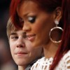 Justin Bieber looks over at Rihanna as they sit courtside during the NBA All-Star basketball game in Los Angeles